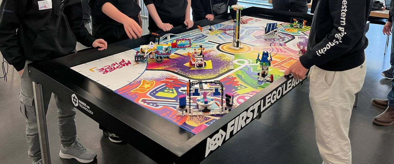 Kinder spielen an einem Tisch mit ihren selbst gebauten Robotern