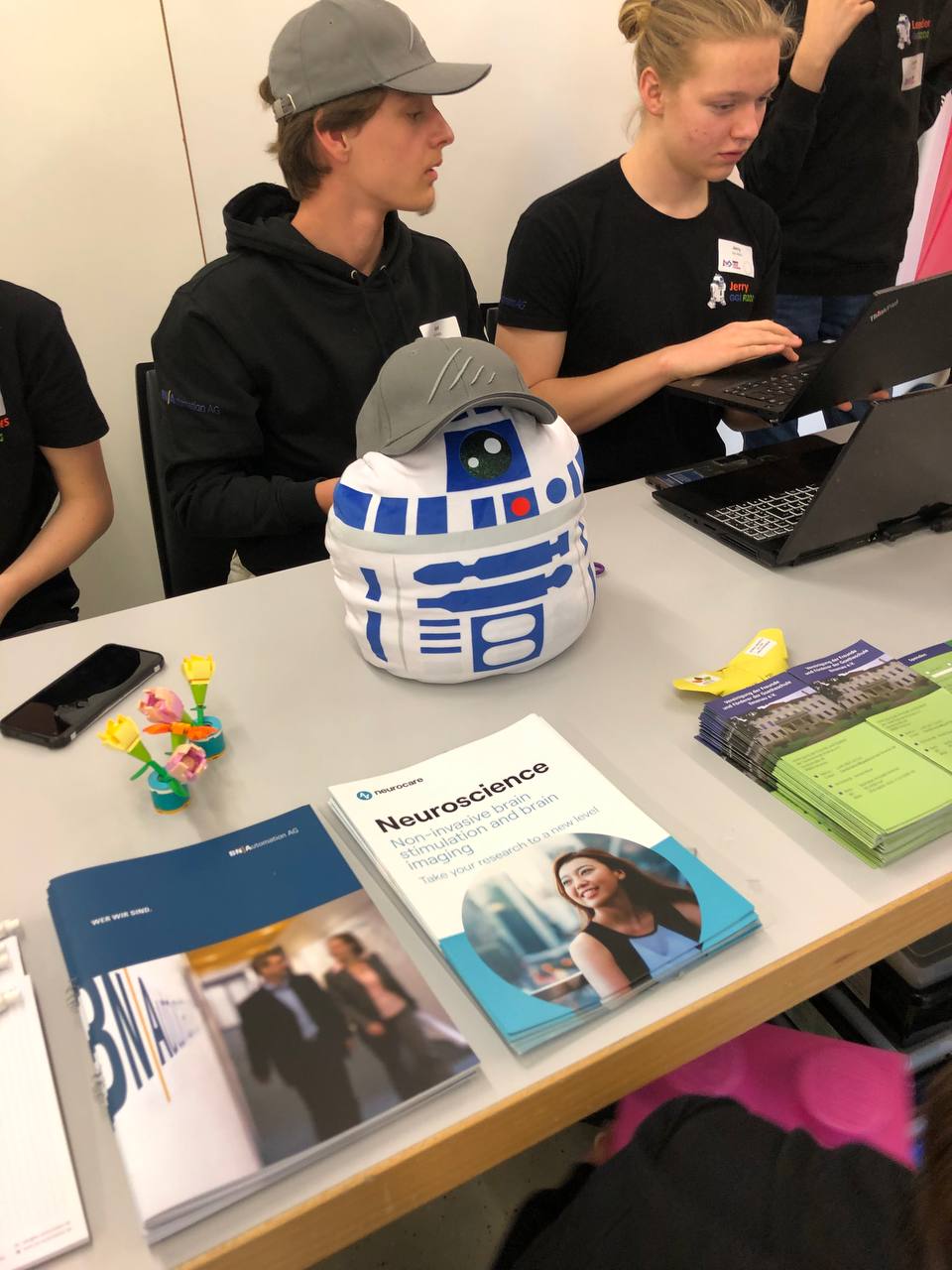 Ein Tisch mit verschiedenen Broschüren und einem C3PO Kuscheltier